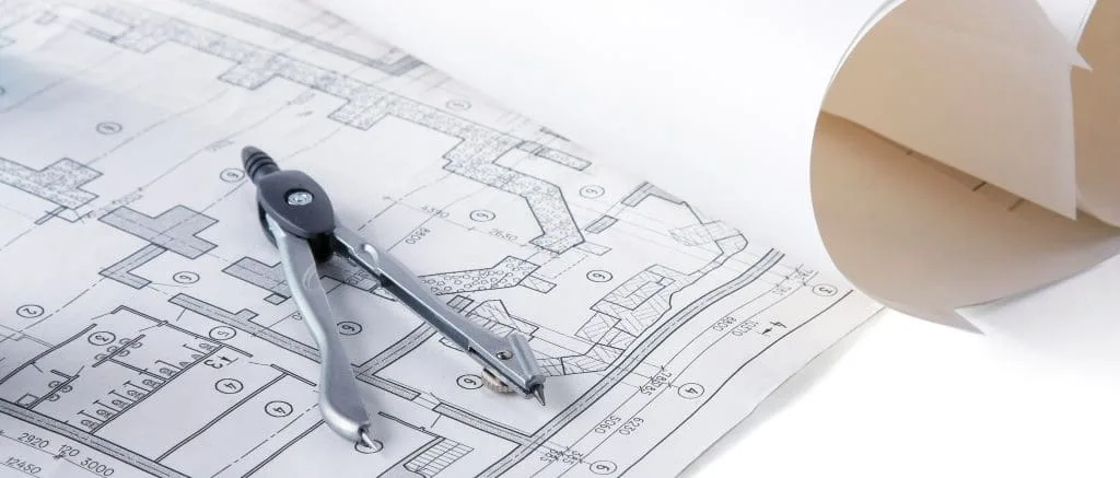 Architectural plans, compass and ruler on a desk