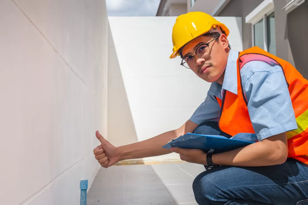 Asian male builder sitting, checking and understanding dilapidation reports